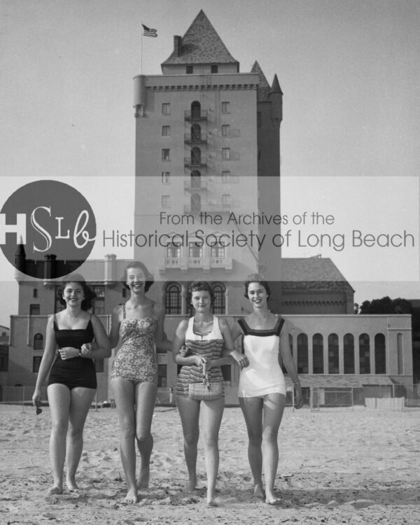Women walking on the beach in front of building